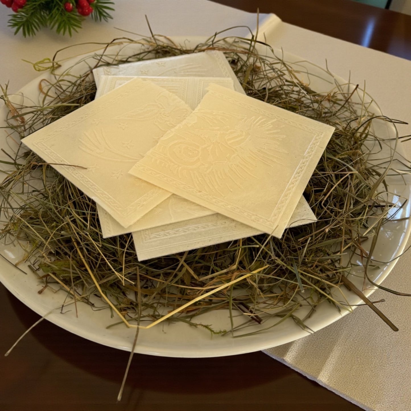 Opłatki wigilijne tradycyjne ułożone na sianie na talerzu symbol Bożego Narodzenia i wieczerzy wigilijnej